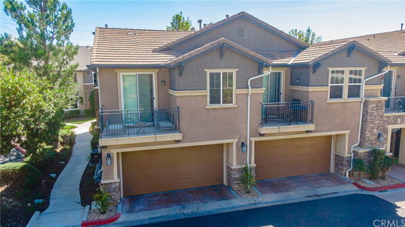 Front view of a multi-story house with balconies and a double garage.