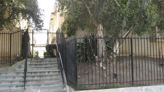 Front steps and entrance to a building with a gated fence.