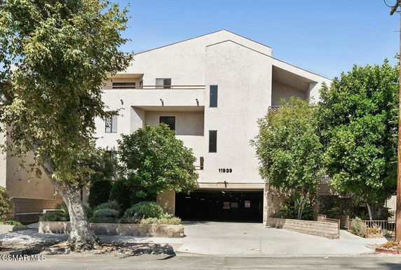 Front view of a multi-story building with parking entrance.
