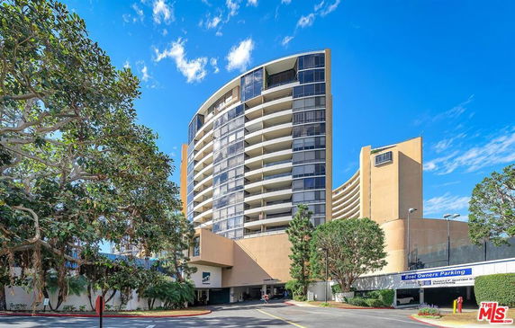 Front view of a multi-story building with a curved facade and balconies.