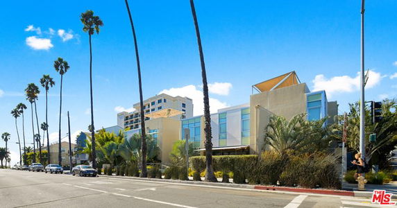 Front view of a modern multi-story building with a distinct angular roof design.