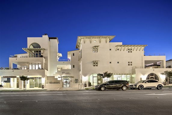 Front view of a modern multi-story building at night.