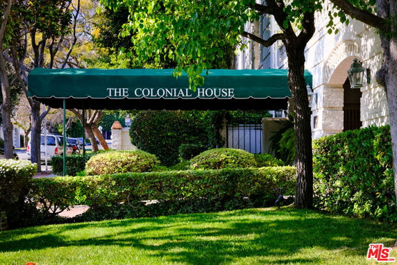 Front view of a building with green canopy entrance labeled 'THE COLONIAL HOUSE.'