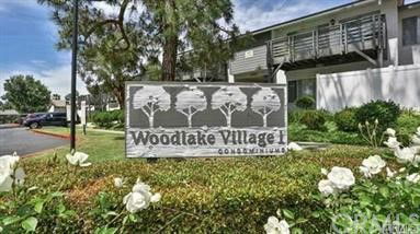Front view of a condominium building with a sign reading 'Woodlake Village.'
