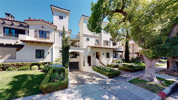 Front view of a multi-story residential building with a Mediterranean architectural style.