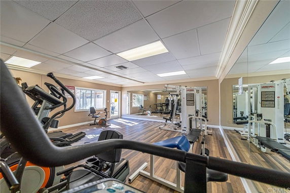 Interior view of a fitness room with gym equipment and mirrors.