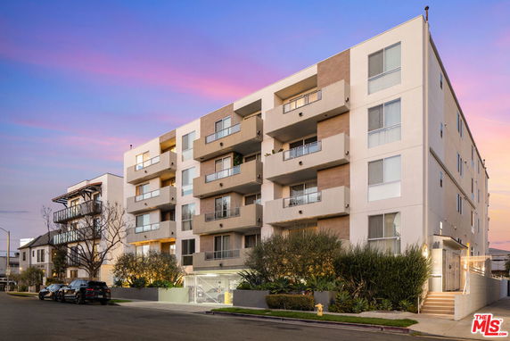Front view of a multi-story apartment building with balconies.