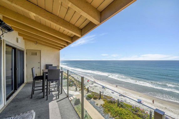 Rooftop patio with ocean view and outdoor seating.