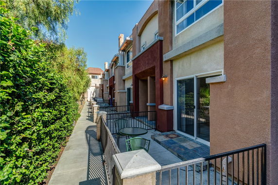 Side view of a multi-story residential building with balconies and sliding doors.