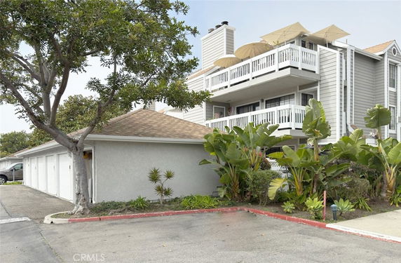 Front view of a multi-story residential building with balconies and a garage area.
