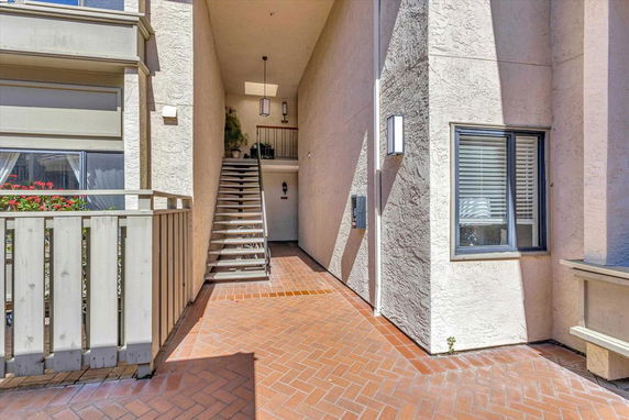 Front view of a multi-story building entrance with stairs leading up.