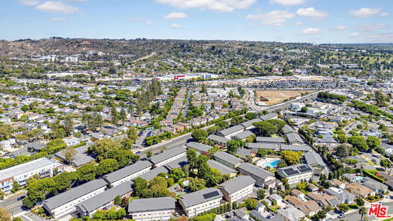 Wide aerial view of a residential area with numerous houses and greenery.
