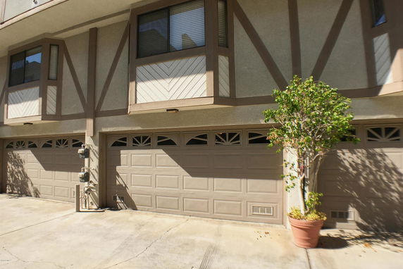 Front view of a multi-story building with two garage doors.