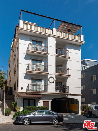 Front view of a multi-story apartment building with balconies.
