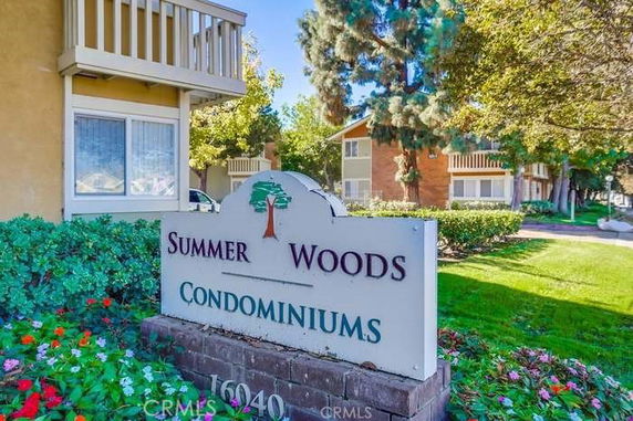 Front view of condominium buildings with a sign reading 'Summer Woods Condominiums'.
