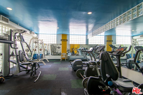 Indoor gym area with exercise equipment and glass block walls.