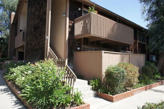 Front view of a two-story building with wooden siding and balconies.