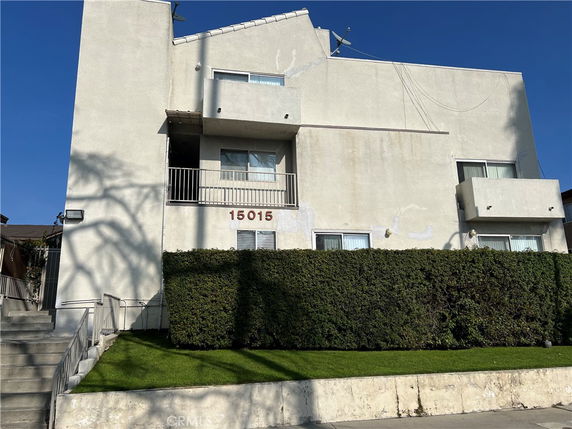 Front view of a multi-story building with balconies and windows.