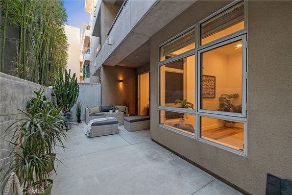 Outdoor patio area beside a building with large windows and outdoor seating.
