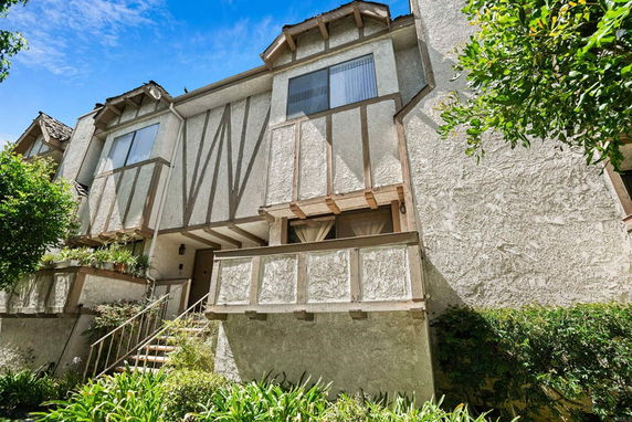 Front view of a two-story house with textured walls and decorative wooden trim.