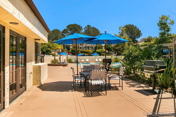 Outdoor area with seating and umbrellas near a swimming pool.