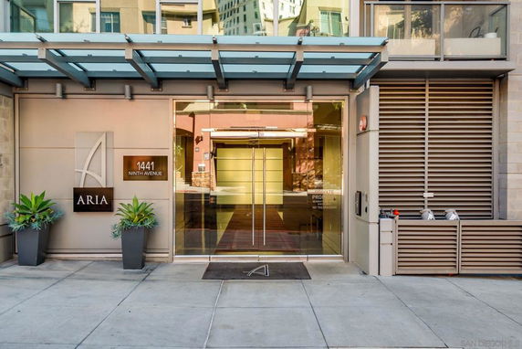 Front view of a modern building entrance with glass doors and a canopy.