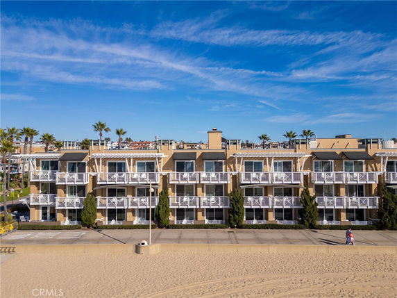Front view of a multi-story beachfront building with balconies.