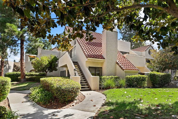 Front view of a two-story house with red tiled roof and stucco walls.