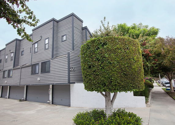 Front view of a multi-story building with garage entrances.