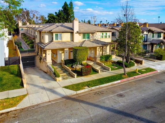 Front view of a multi-story townhouse with a driveway and garage.
