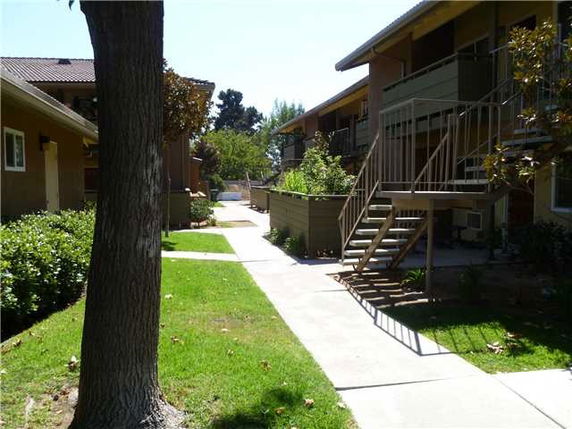 Exterior view of multi-story apartment buildings with staircases and pathways.
