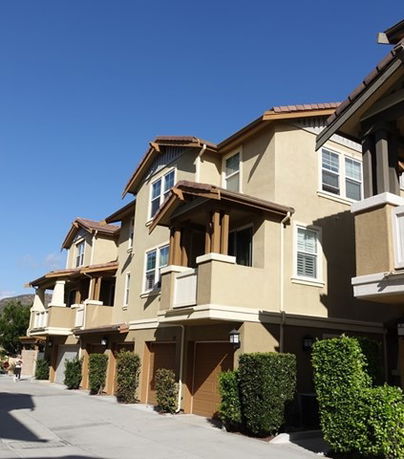 Front view of a multi-story residential building with multiple units and garage doors.