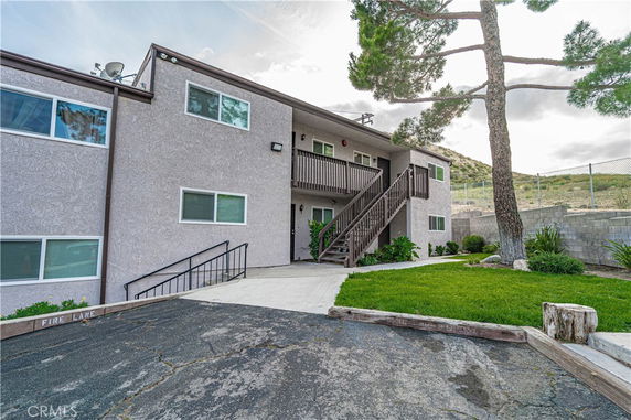 Front view of a multi-story apartment building with exterior stairs.