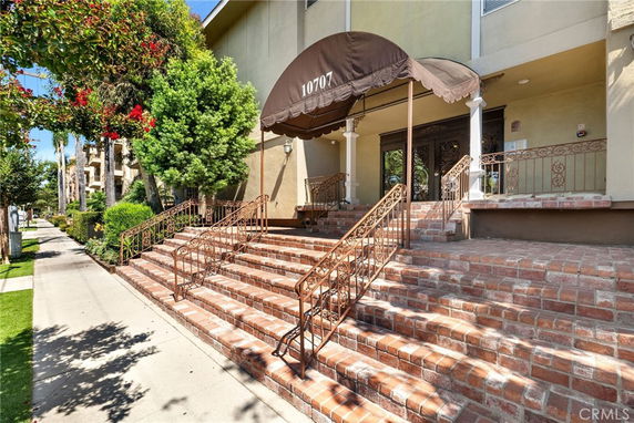 Front view of a building with brick steps and a canopy entrance.