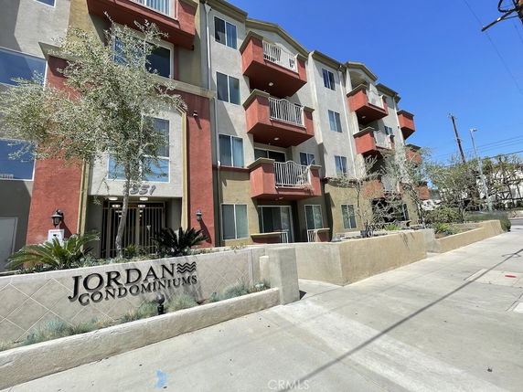 Front view of a multi-story condominium building with balconies.