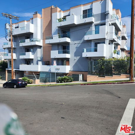 Front view of a multi-story residential building with balconies.