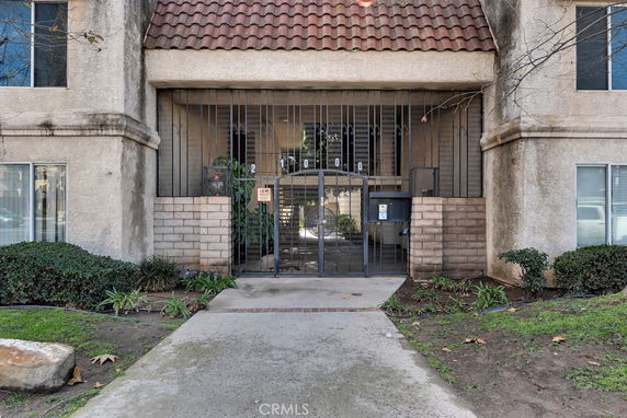 Front view of a multi-story building with gated entry.