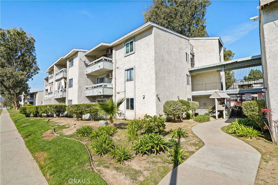 Front view of a multi-story apartment building with balconies.