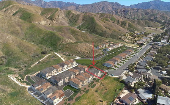 Panoramic view of a residential area with houses and surrounding hills.