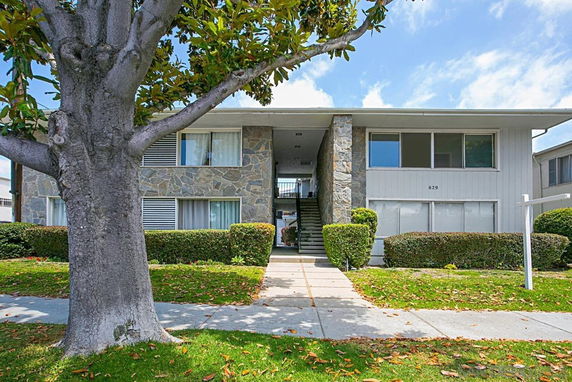 Front view of a two-story residential building with stone and siding exterior.