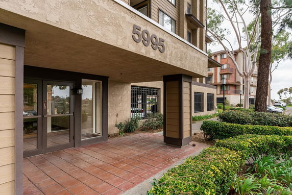 Front entrance of a multi-story building with the number 5995 displayed above the door.
