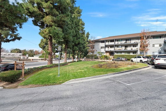 Front view of a multi-story residential building with balconies and parking area.