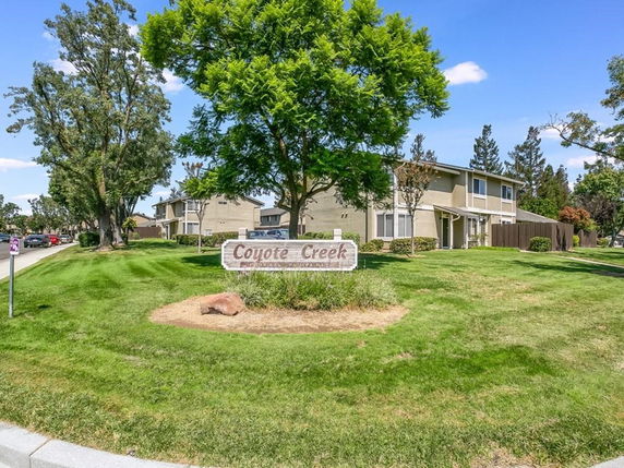 Front view of a two-story apartment building with a sign reading 'Coyote Creek'.