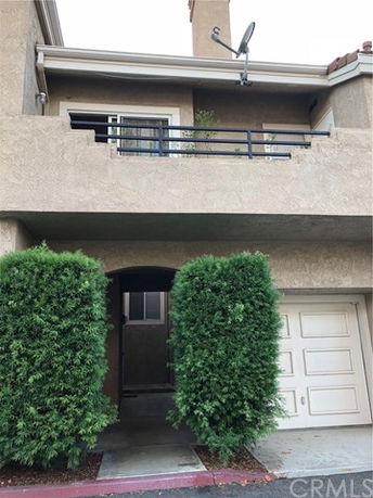 Front view of a two-story house with a balcony and garage.