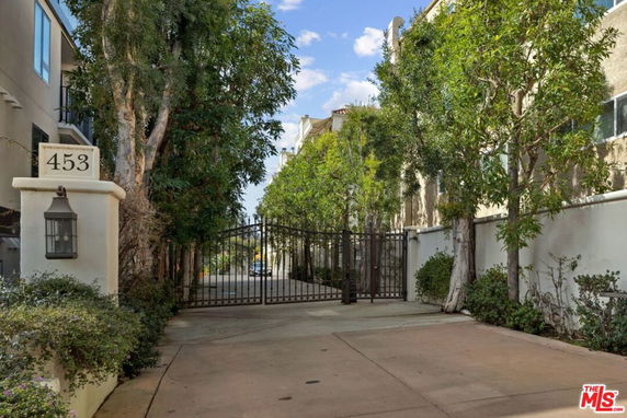 Front view of a gated residential complex entrance with a tall fence and unit number 453.