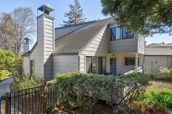 Front view of a two-story house with multiple roof sections and chimney.