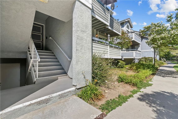 Entrance view of a multi-level apartment building with external stairway.