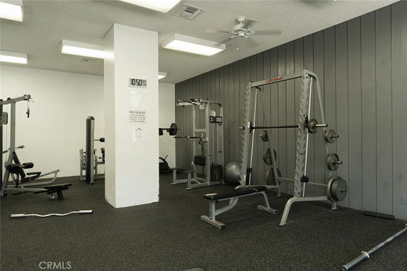 Indoor gym area with exercise equipment and weights.