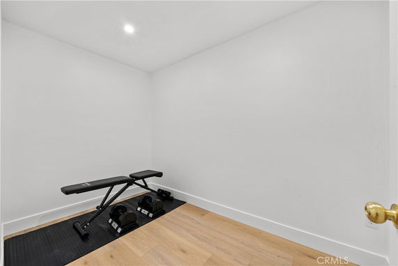 Small indoor workout area with a bench and dumbbells.