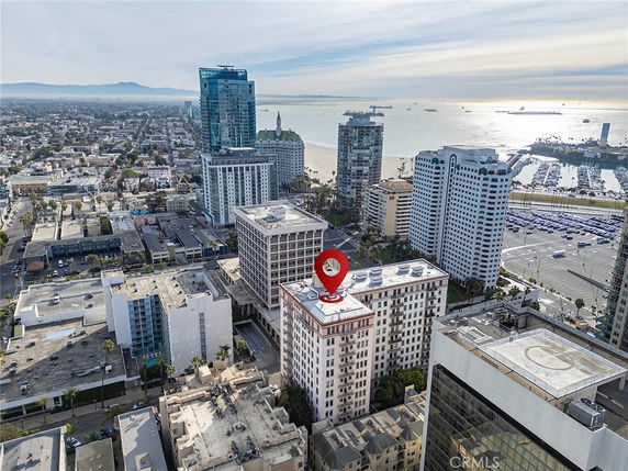 Aerial view of a coastal cityscape with multiple high-rise buildings and the ocean in the background.